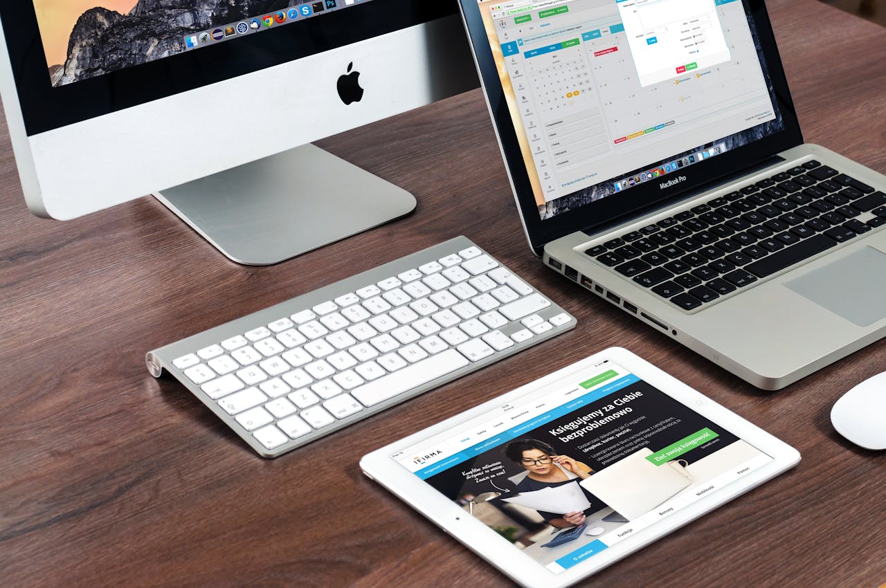 Services A sleek office desk setup featuring Apple devices: iMac, MacBook, and iPad.